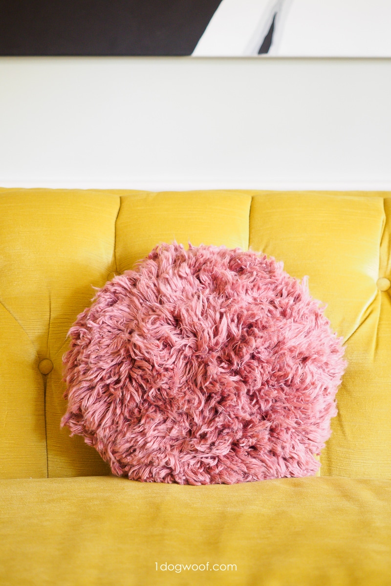 在黄色的沙发上粉红色的粗毛抱枕