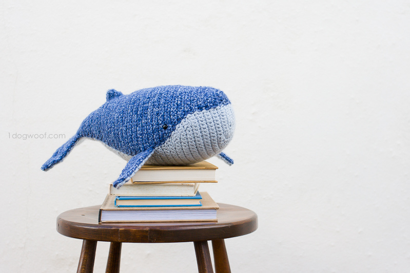 婴儿座头鲸的镂空坐在一摞书上