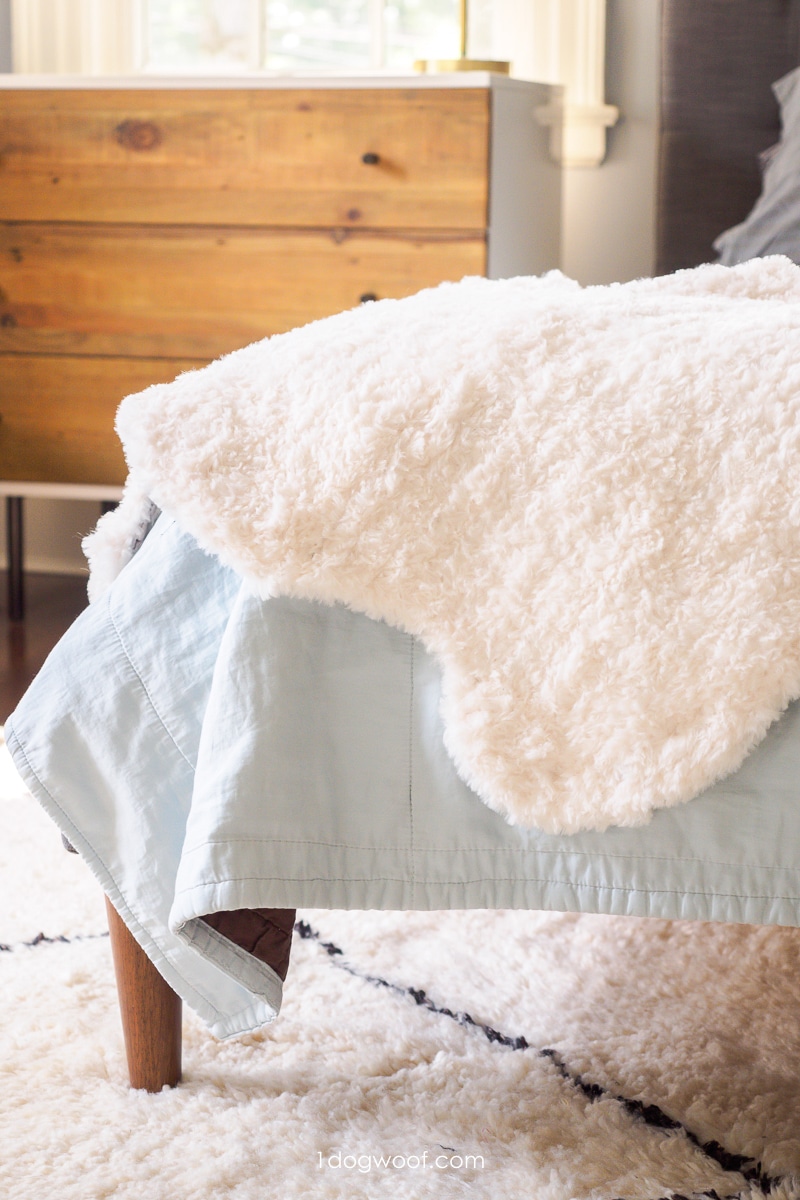 faux fur alpine sheepskin draped over corner of bed