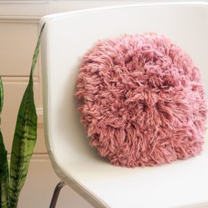 白色椅子上的粉红色粗毛枕头